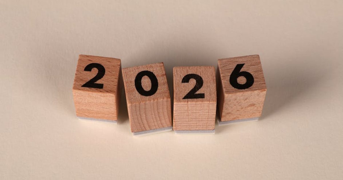 Wooden cubes forming the year 2026 on a neutral background.
