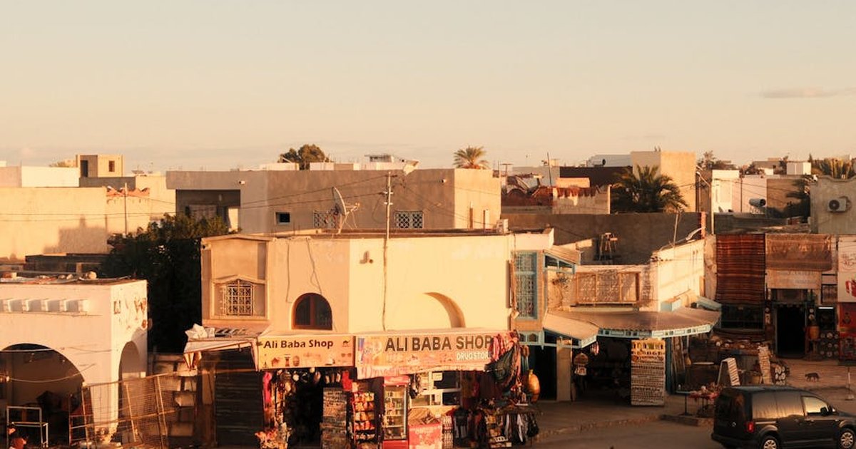 Charming view of a street market at sunset in El Jem, Tunisia, capturing local culture.