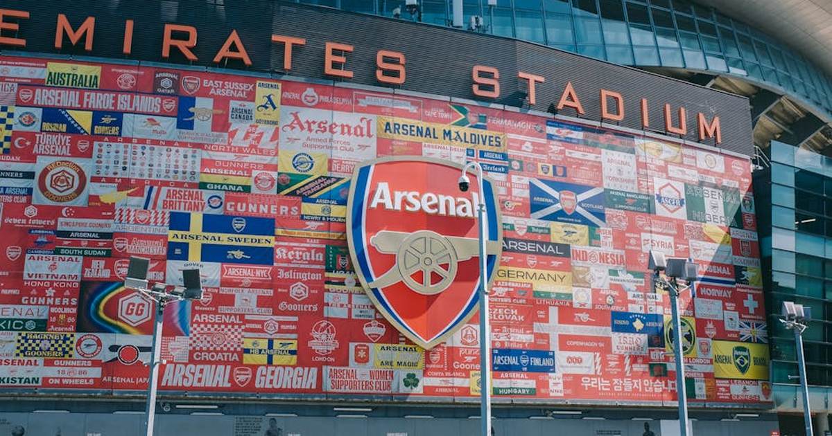 Vibrant wall art at Emirates Stadium featuring Arsenal flags and crest in London, UK.