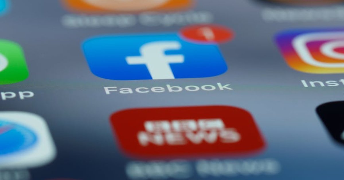 Close-up of smartphone screen displaying various social media app icons including Facebook.