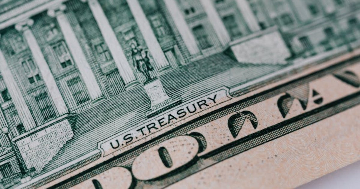 From above ten dollar banknote with inscription and United States treasury building placed on table