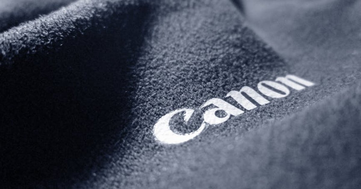 A detailed close-up of a black fabric with embroidered text, showcasing texture and material quality.