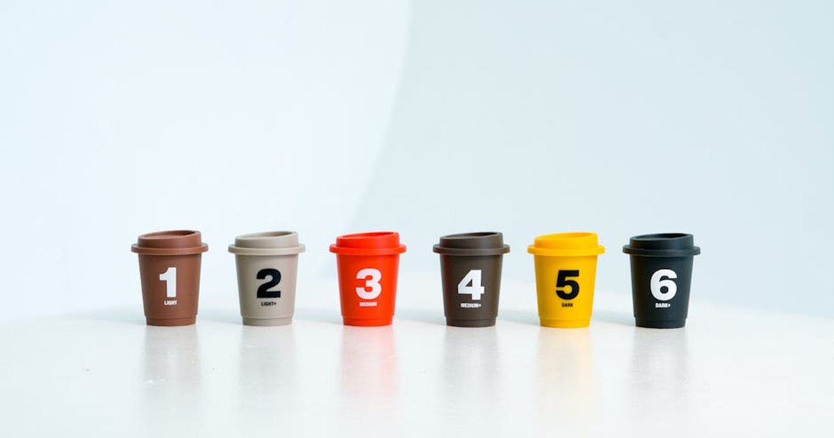A set of colorful toy cups labeled from 1 to 6, aligned in a row on a white surface.