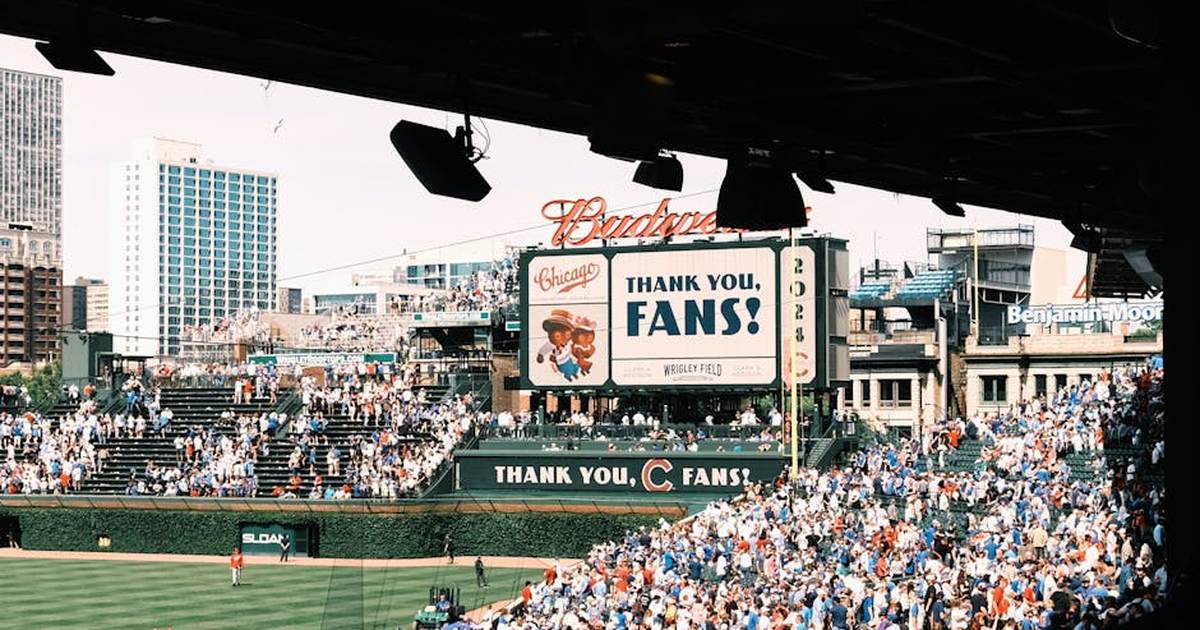 Crowd enjoying a baseball game at Wrigley Field, Chicago's iconic stadium, on a sunny day.