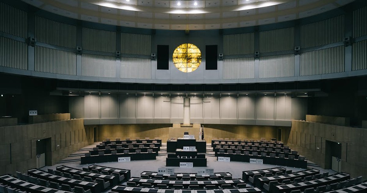 Interior of a modern legislative chamber with empty seats and a unique architectural design in Tokyo, Japan.