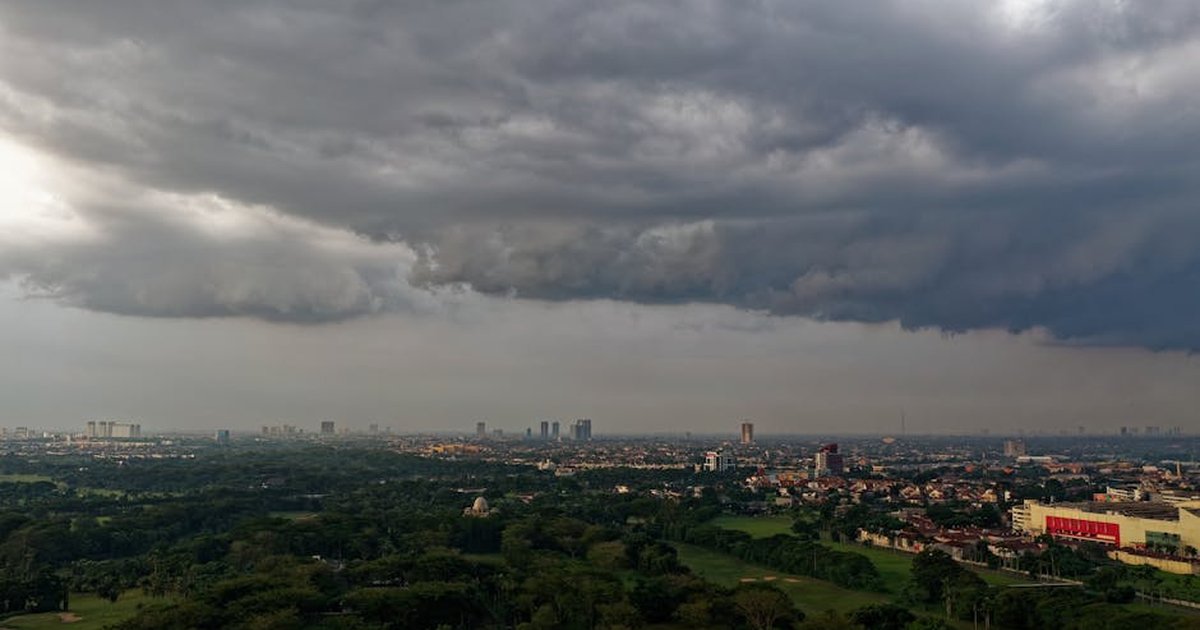 Dramatic aerial view of storm clouds over Serpong, Indonesia's urban and natural landscape.
