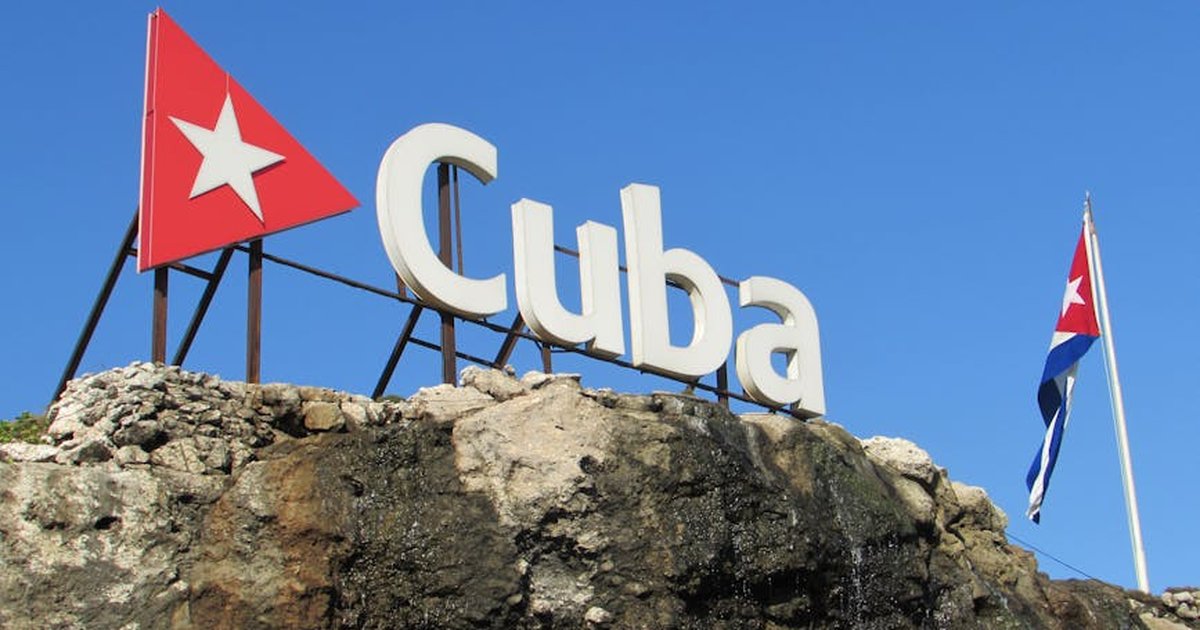 Cuba sign and flag against a clear blue sky in Havana, Cuba.