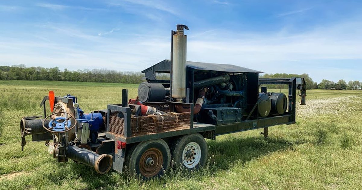Diesel engine water pump in a Smithville field under clear sky.