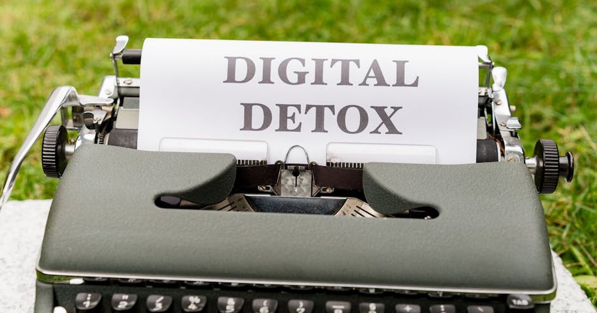 A classic typewriter displaying the words 'Digital Detox' outdoors, symbolizing a break from technology.