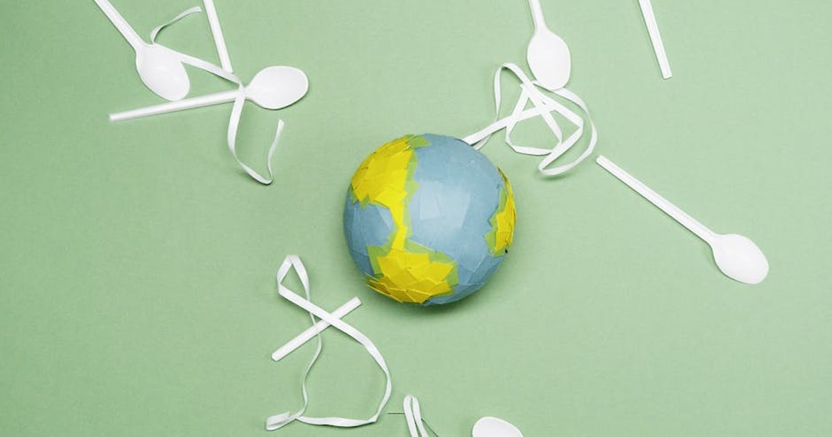 Illustration of Earth's environment impacted by plastic waste on a green background.