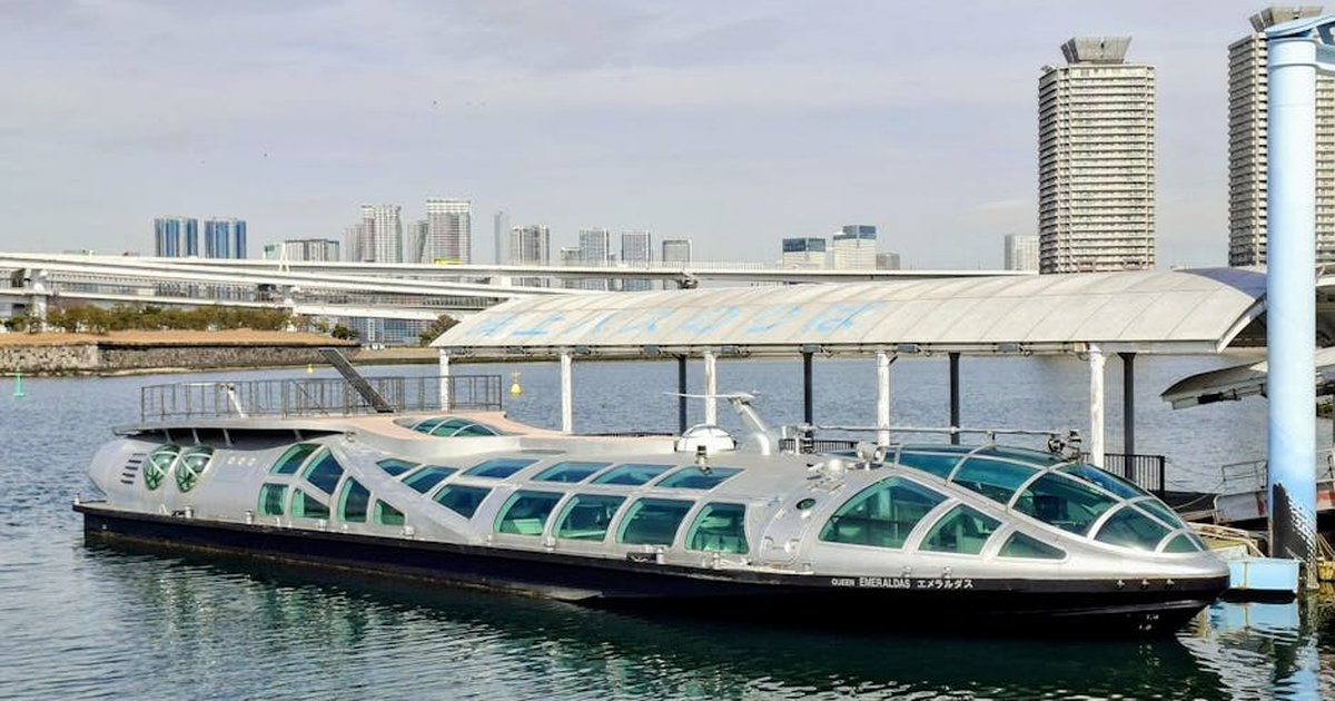 A sleek futuristic boat docked in modern Tokyo, Japan with skyline views.
