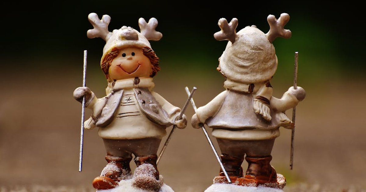 Charming winter figurines with antler hats holding ski poles, perfect for holiday decor.