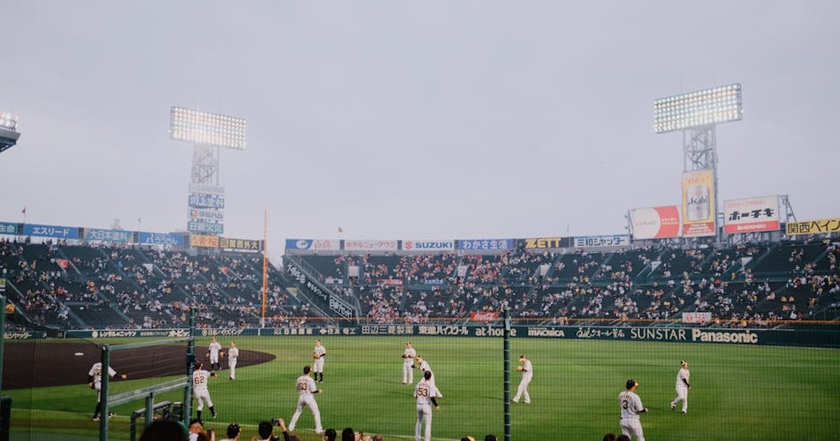 Players and spectators enjoy a vibrant baseball game at Hanshin Koshien Stadium, Japan.