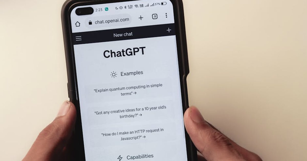 Close-up of hands holding a smartphone displaying the ChatGPT application interface on the screen.