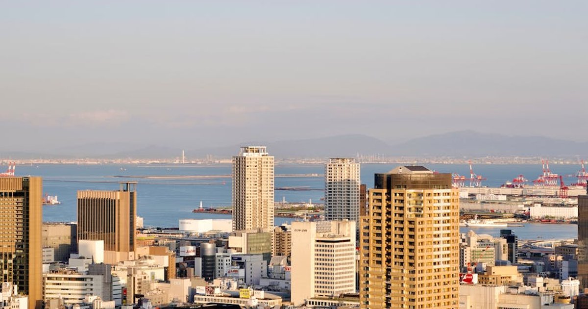 An urban skyline with skyscrapers and waterfront in soft daylight, showcasing modern architecture.