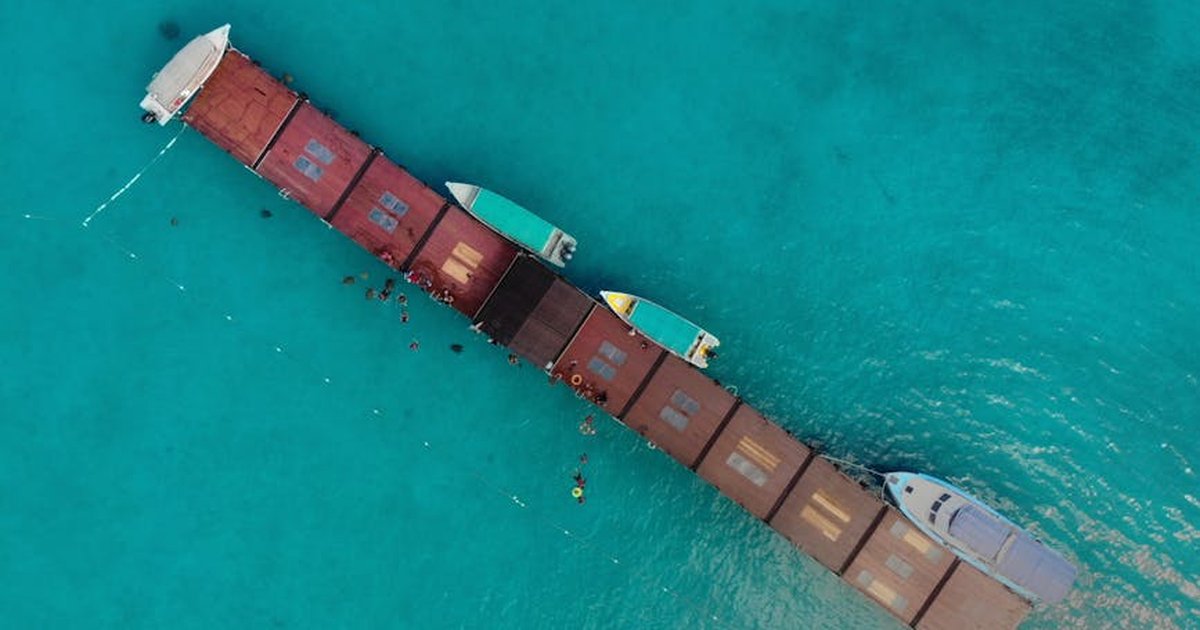 Aerial shot of a pier with boats in clear turquoise water, Kuala Terengganu, Malaysia.