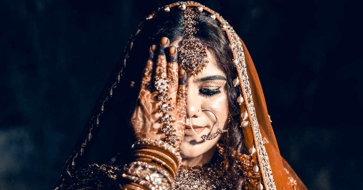 Beautiful Indian bride in traditional attire with intricate henna design, symbolizing love and prosperity.