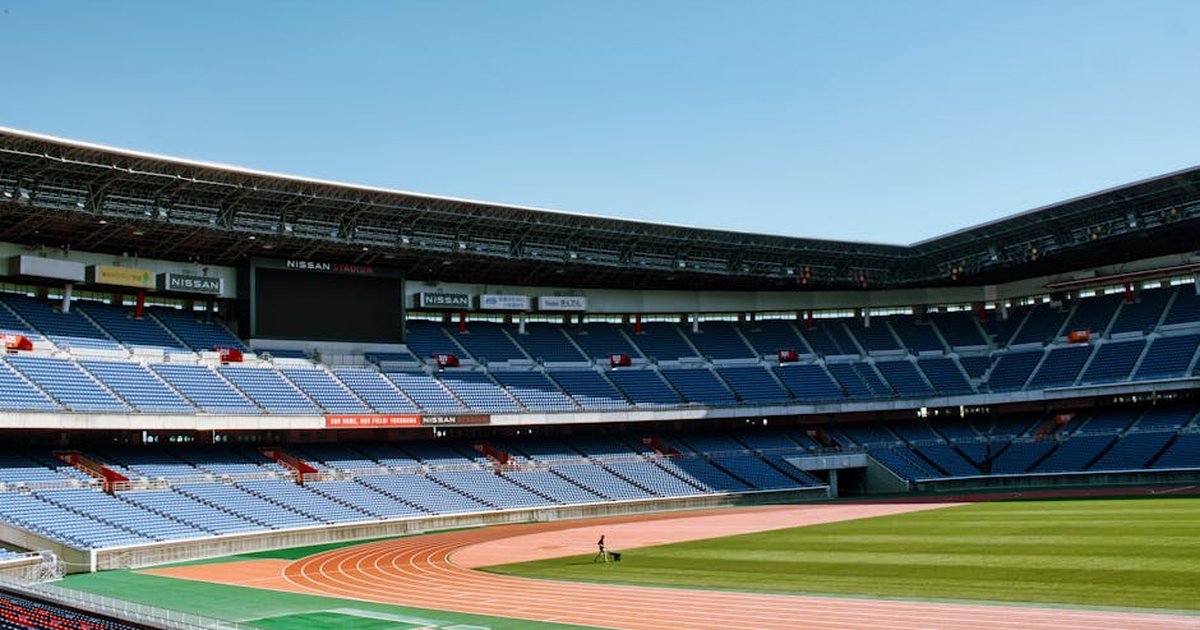 Wide-angle shot of empty Nissan Stadium in Yokohama, Japan, with clear blue skies.