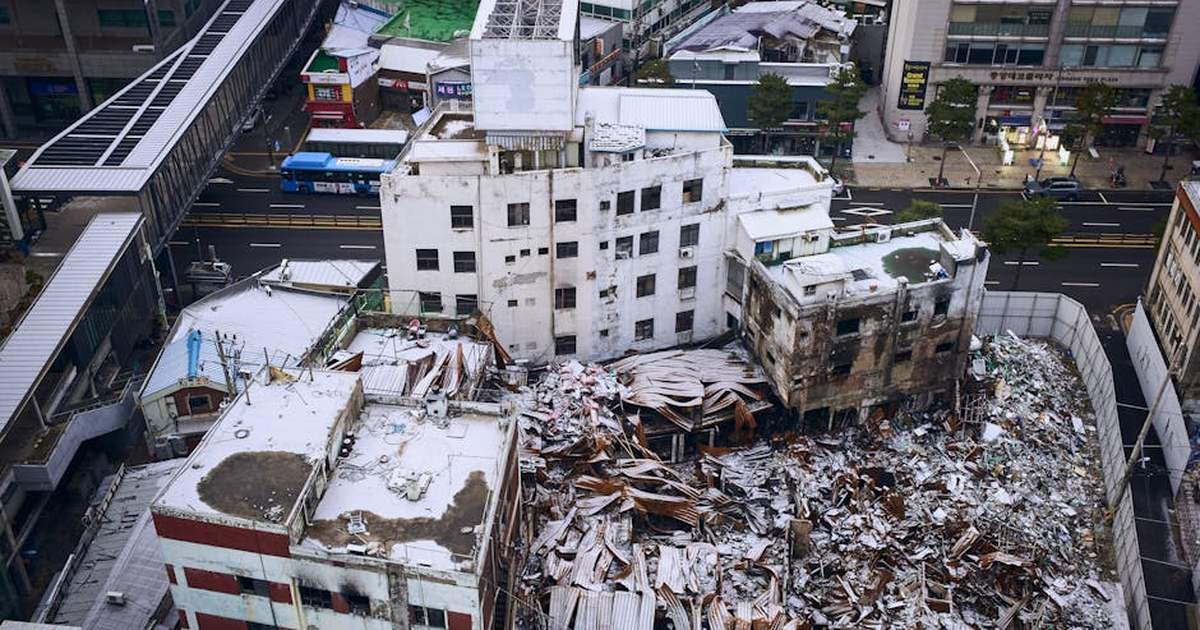 Aerial shot of a demolished building amidst cityscape, showcasing urban decay and reconstruction.