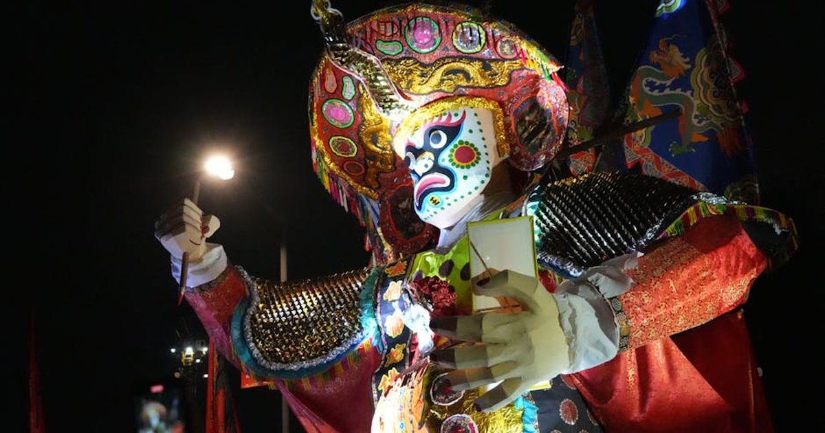 A colorful traditional costume illuminated at night during a festival in New Territories, Hong Kong.