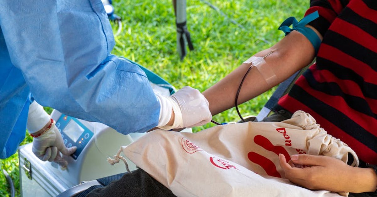 A person donating blood outdoors in Piura, Peru, emphasizing life-saving charity.