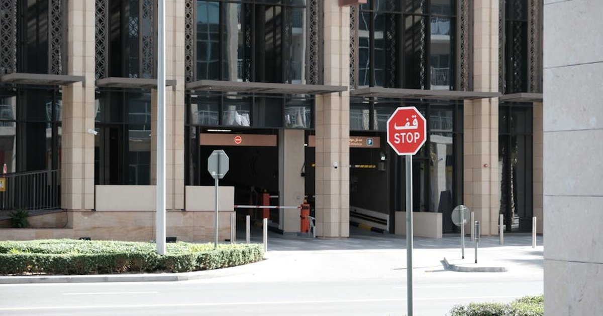 A contemporary building in Dubai featuring a bilingual stop sign, epitomizing urban life and road safety.