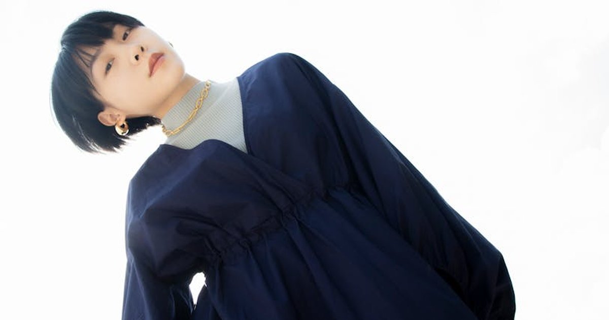 Elegant portrait of a woman in a dark dress with minimalistic style and dramatic light.