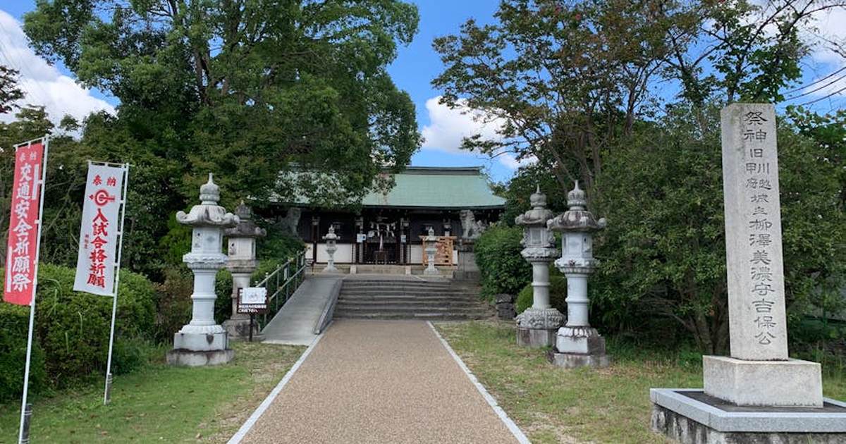 A peaceful entrance to a traditional Japanese shrine surrounded by lush greenery.