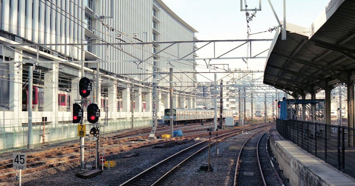 Captured railway tracks at a train station in Kyoto, Japan, with modern architecture.