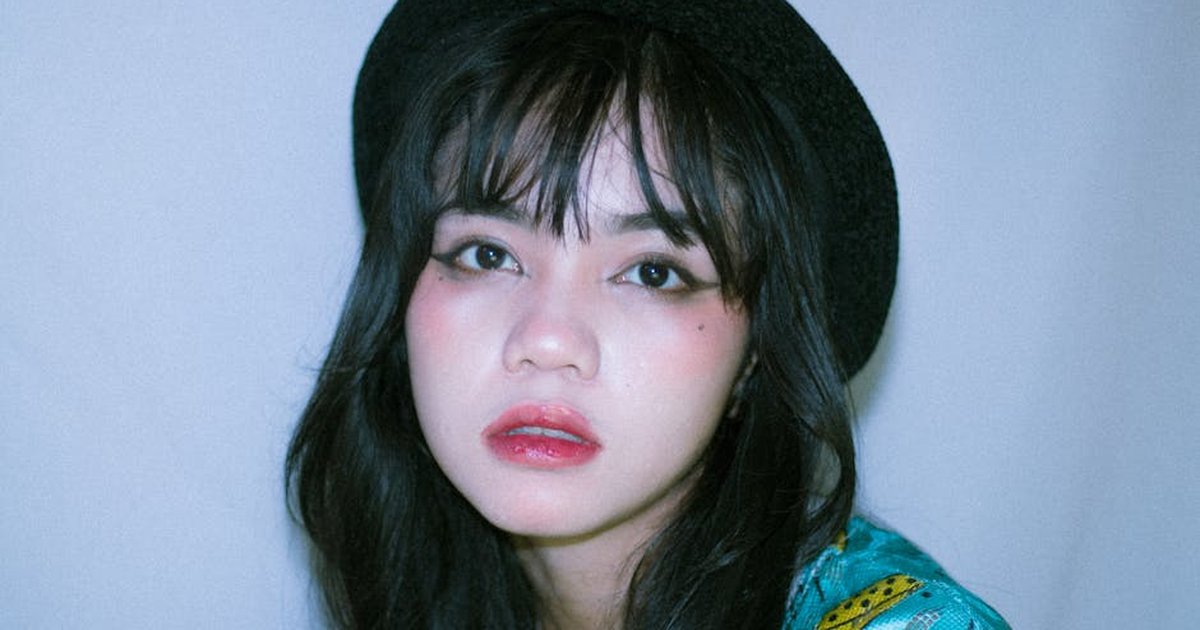 Detailed close-up portrait of an Asian teenager wearing a stylish hat, perfect for fashion and lifestyle content.
