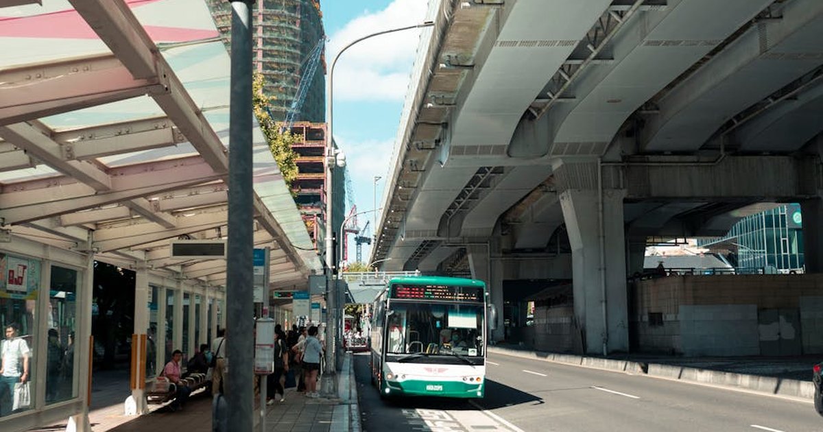 Urban scene capturing a bus under an elevated highway in Taipei City, Taiwan.