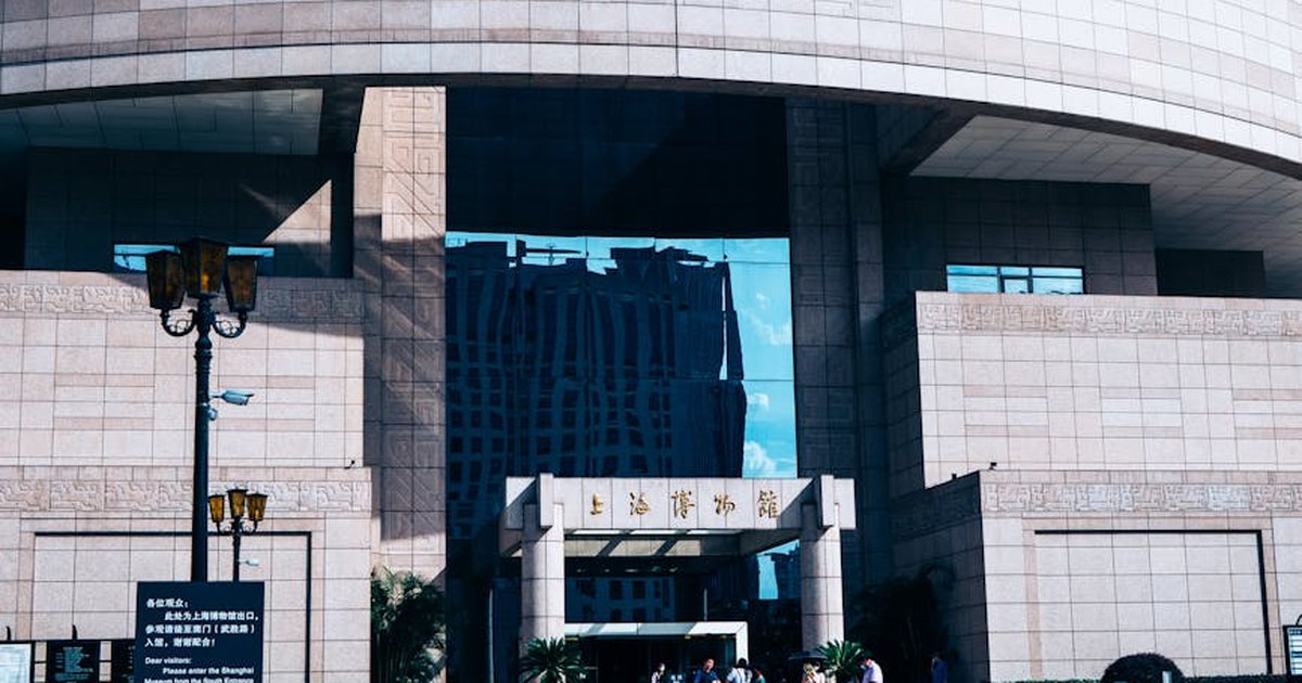 The grand entrance of Shanghai Museum showcasing modern architecture under a clear blue sky.
