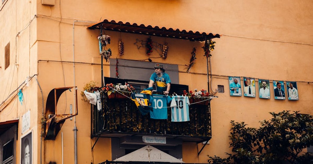 A balcony decorated with football jerseys and player photographs, showcasing a tribute to soccer legends.