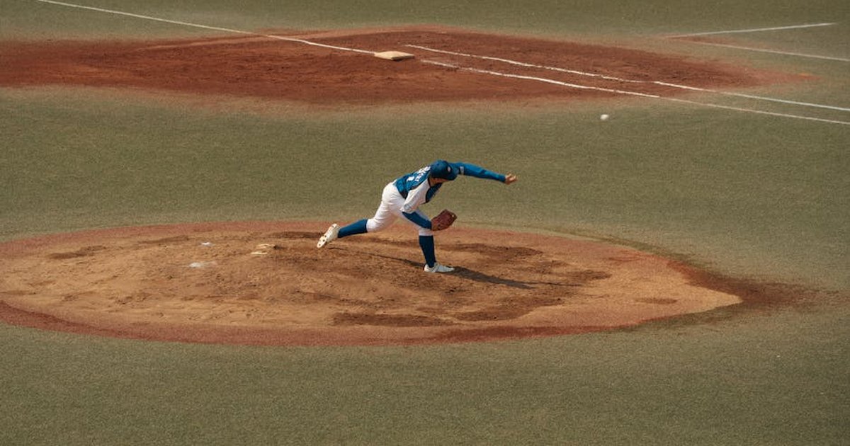 A skilled baseball pitcher delivers a pitch on a sunlit field in Tokyo, Japan. Captured in dynamic motion.