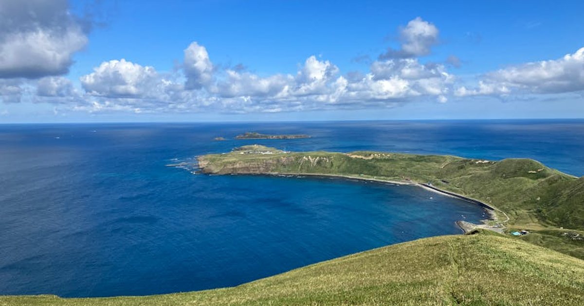 A breathtaking view of Rebun Island's coastline with blue sea and sky, perfect for summer travel inspiration.