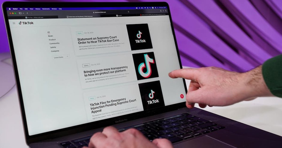 Close-up of a person interacting with TikTok content on a laptop indoors.