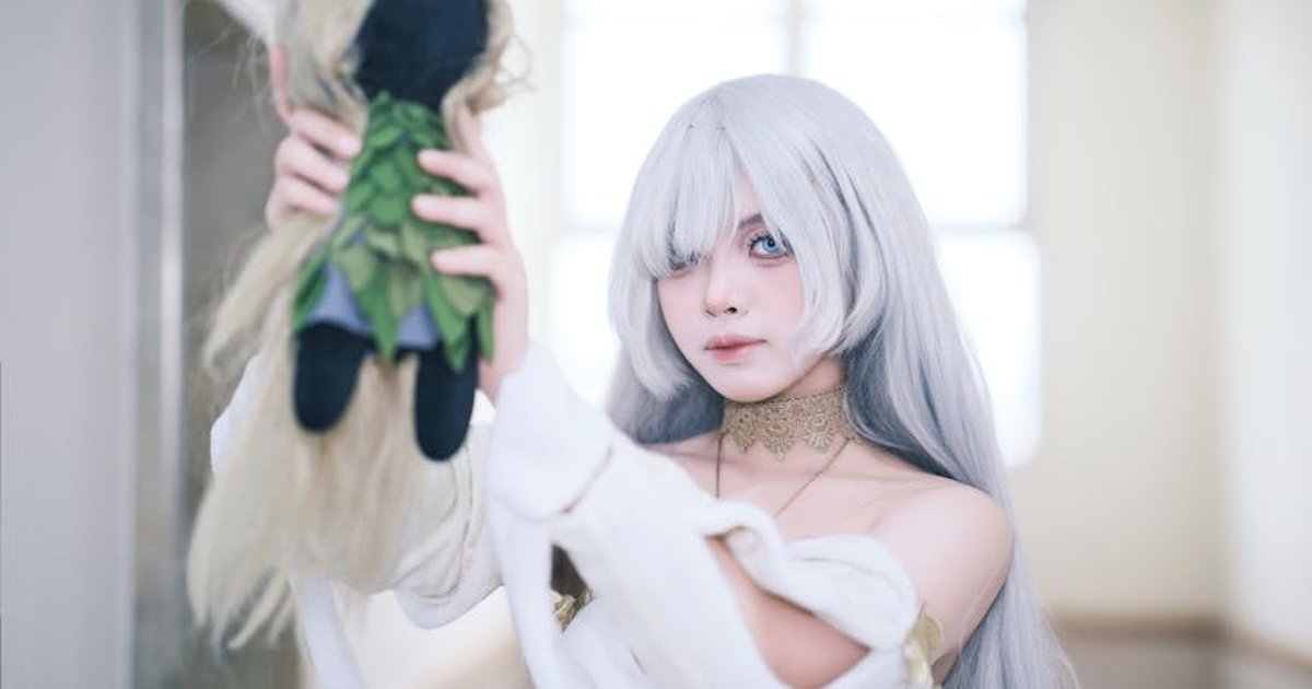 Enchanting cosplay with a young woman in a silver-haired outfit, indoors.