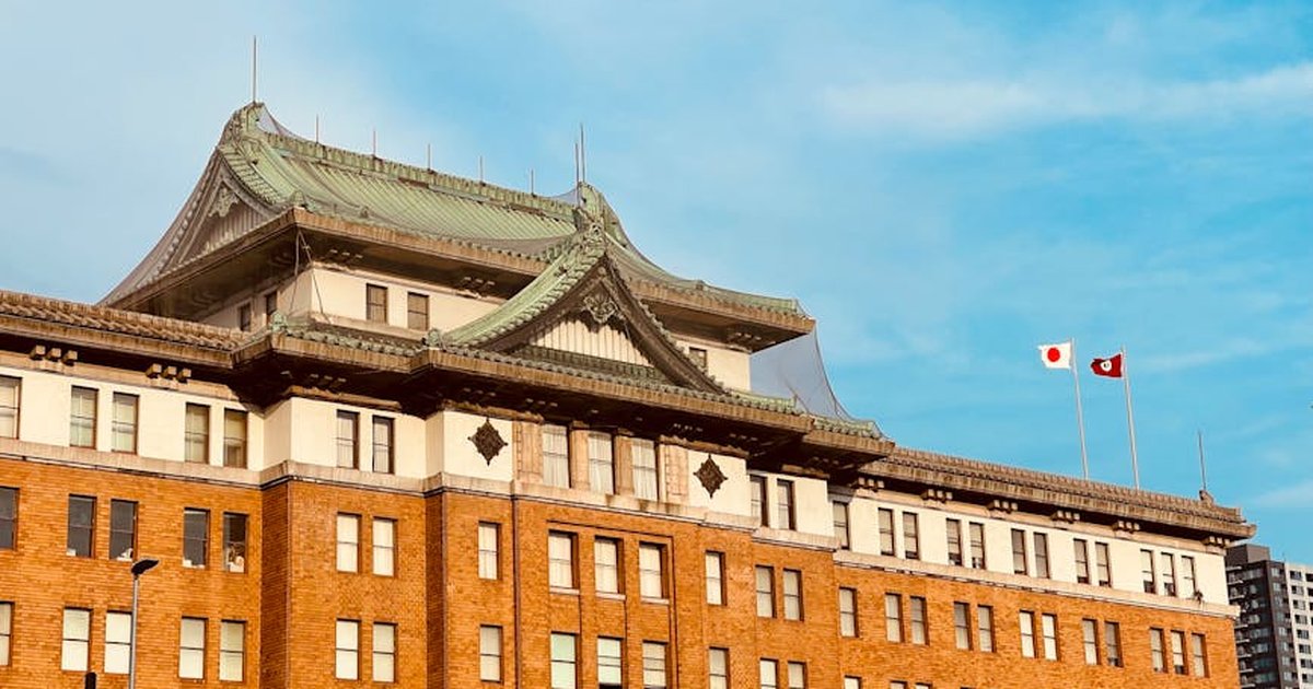 Historic government building facade in Nagoya showcasing imperial crown style architecture under a bright blue sky.