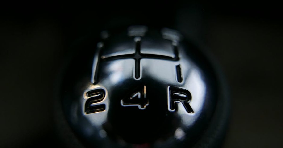 Detailed view of a manual shift knob inside a vehicle, showcasing gear arrangements.
