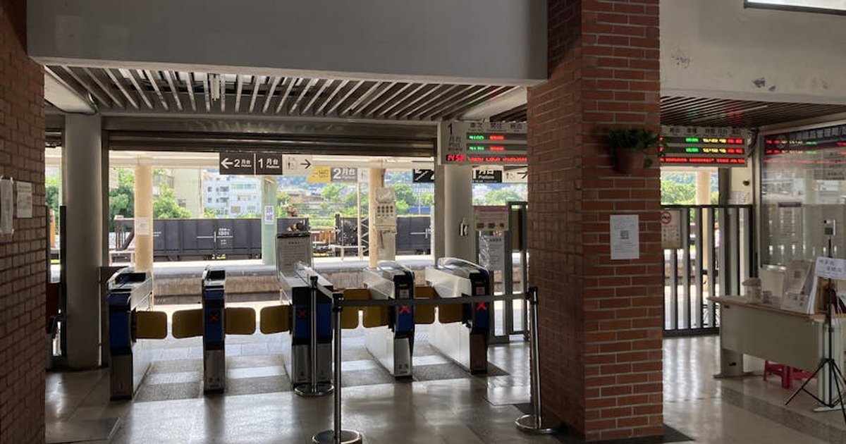 Entrance of train station in Yilan, Taiwan, featuring automated gates and red brick columns.
