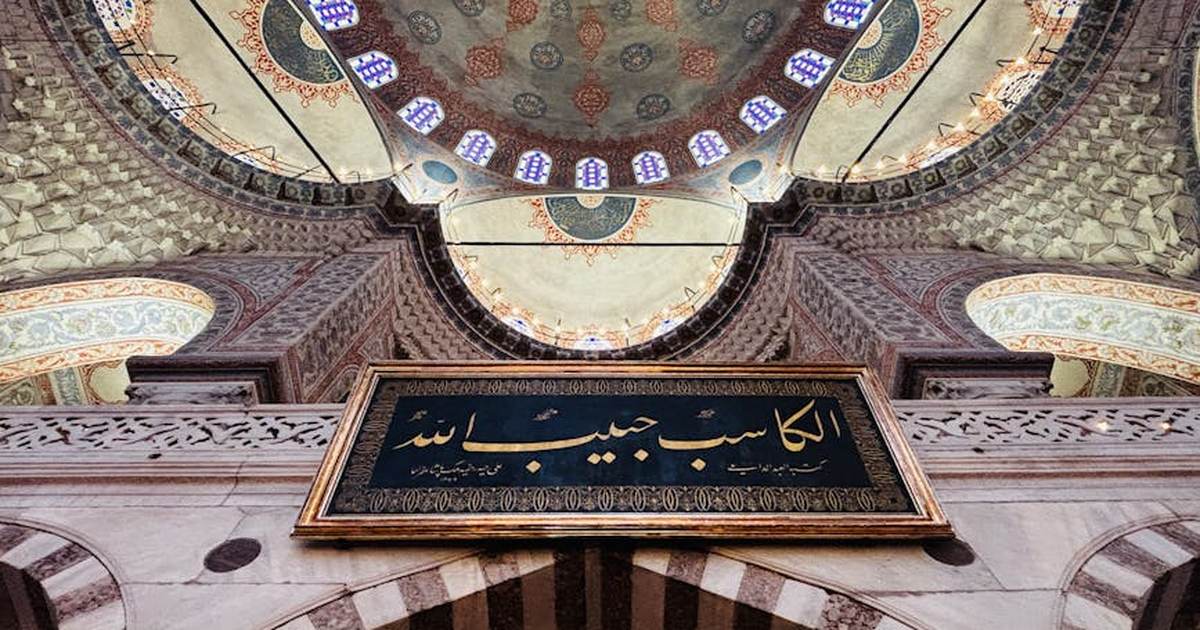 Stunning view of a mosque's ornate ceiling with Arabic calligraphy in Istanbul, Turkey.