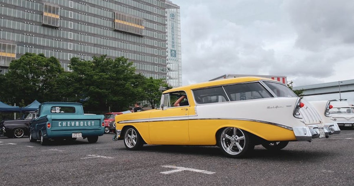 Vintage Chevrolet cars showcased at an outdoor meetup in a city parking lot.