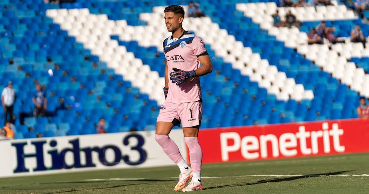 Goalkeeper wearing pink kit on the soccer field during a match.