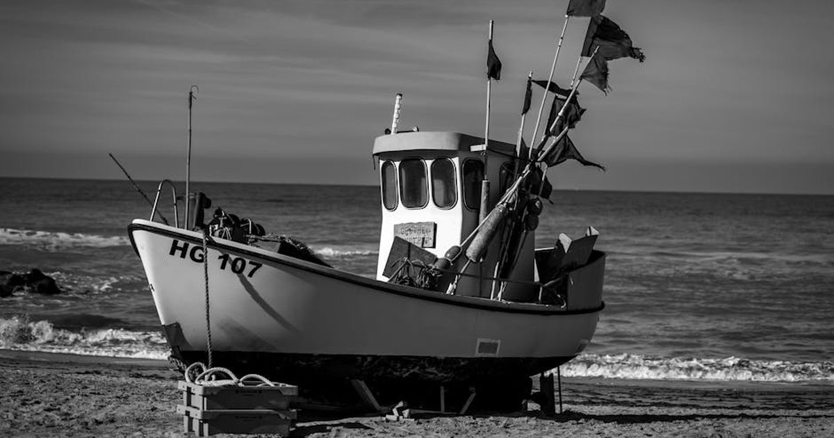 A monochrome photo of a fishing boat on Lønstrup beach, Denmark, capturing the marine ambiance.