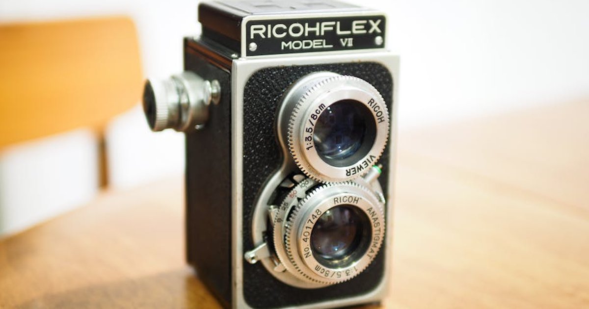 Close-up of a vintage Ricohflex Model VI twin-lens reflex camera on a wooden table.