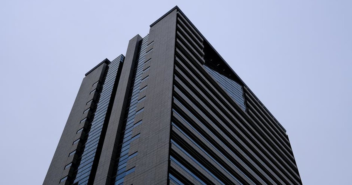 A low-angle view of a modern skyscraper in Tokyo, Japan, captured against a clear sky.
