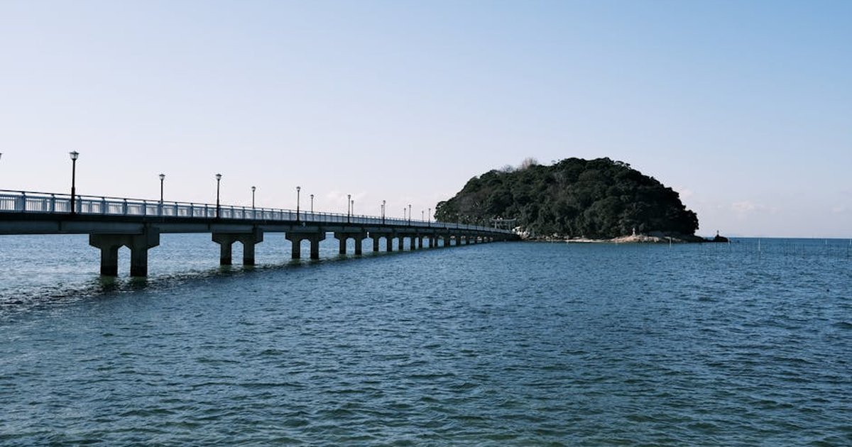 A serene ocean view featuring a bridge leading to an island in Gamagōri, Japan.