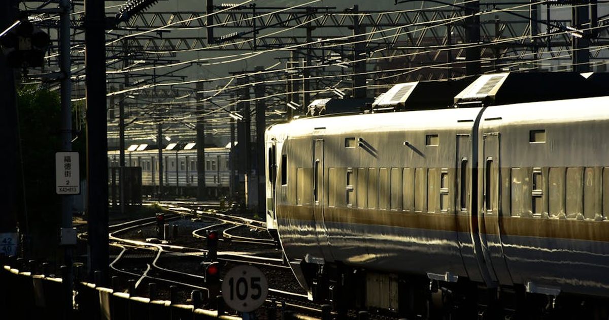 Dynamic image of a high-speed train navigating through complex urban rail tracks at dusk.