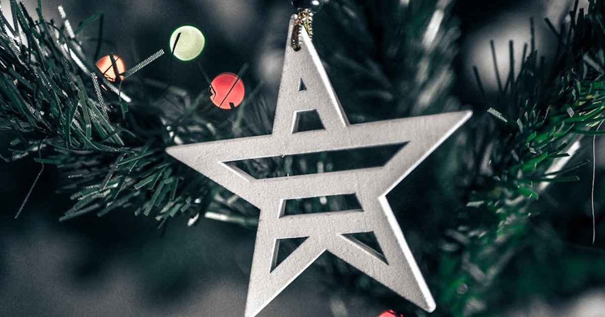 Close-up of a star-shaped ornament on a Christmas tree, capturing festive spirit.