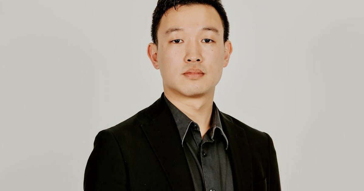Portrait of a young adult in a formal suit, isolated on a neutral background.